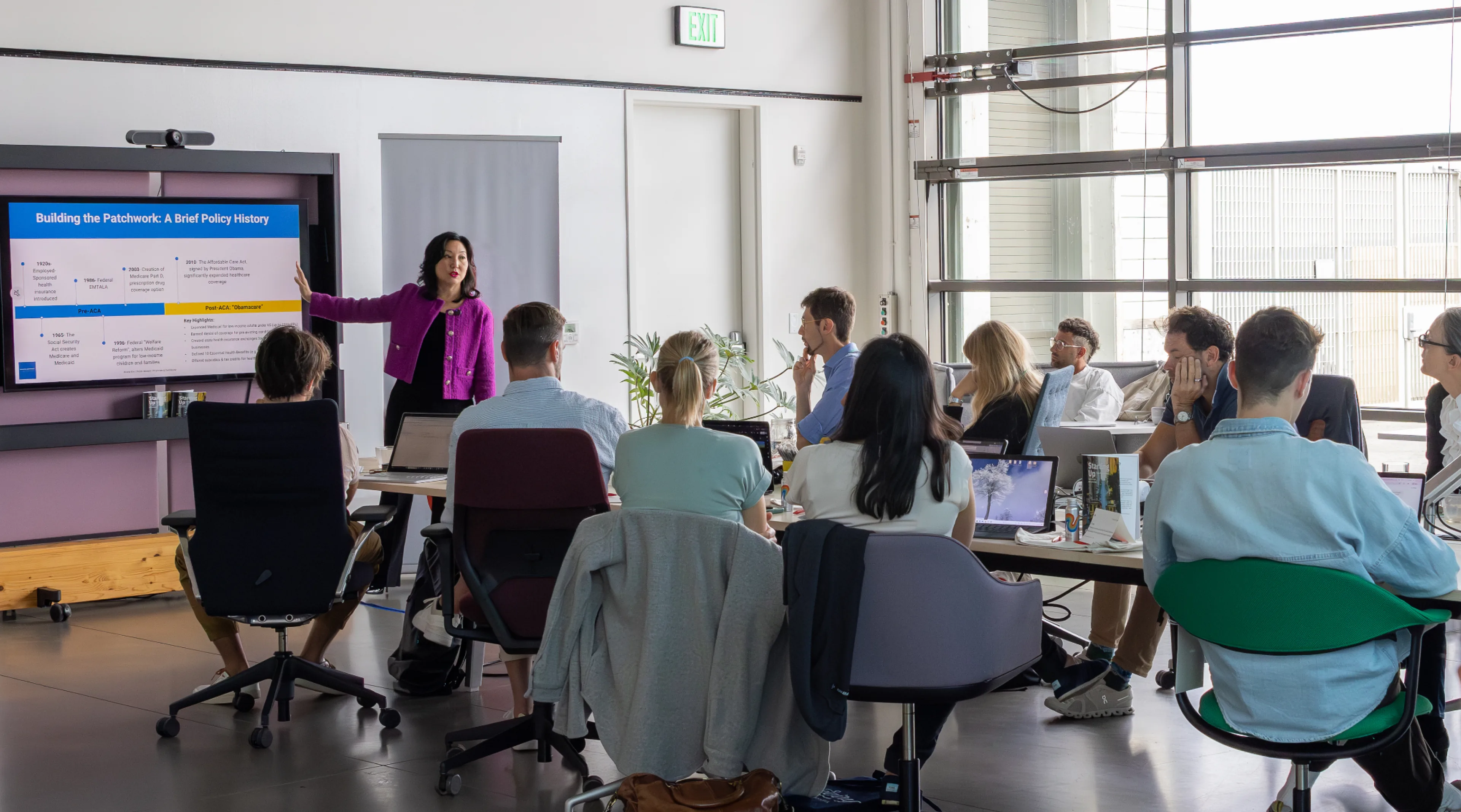 Carol Kim presenting to a room of colleagues